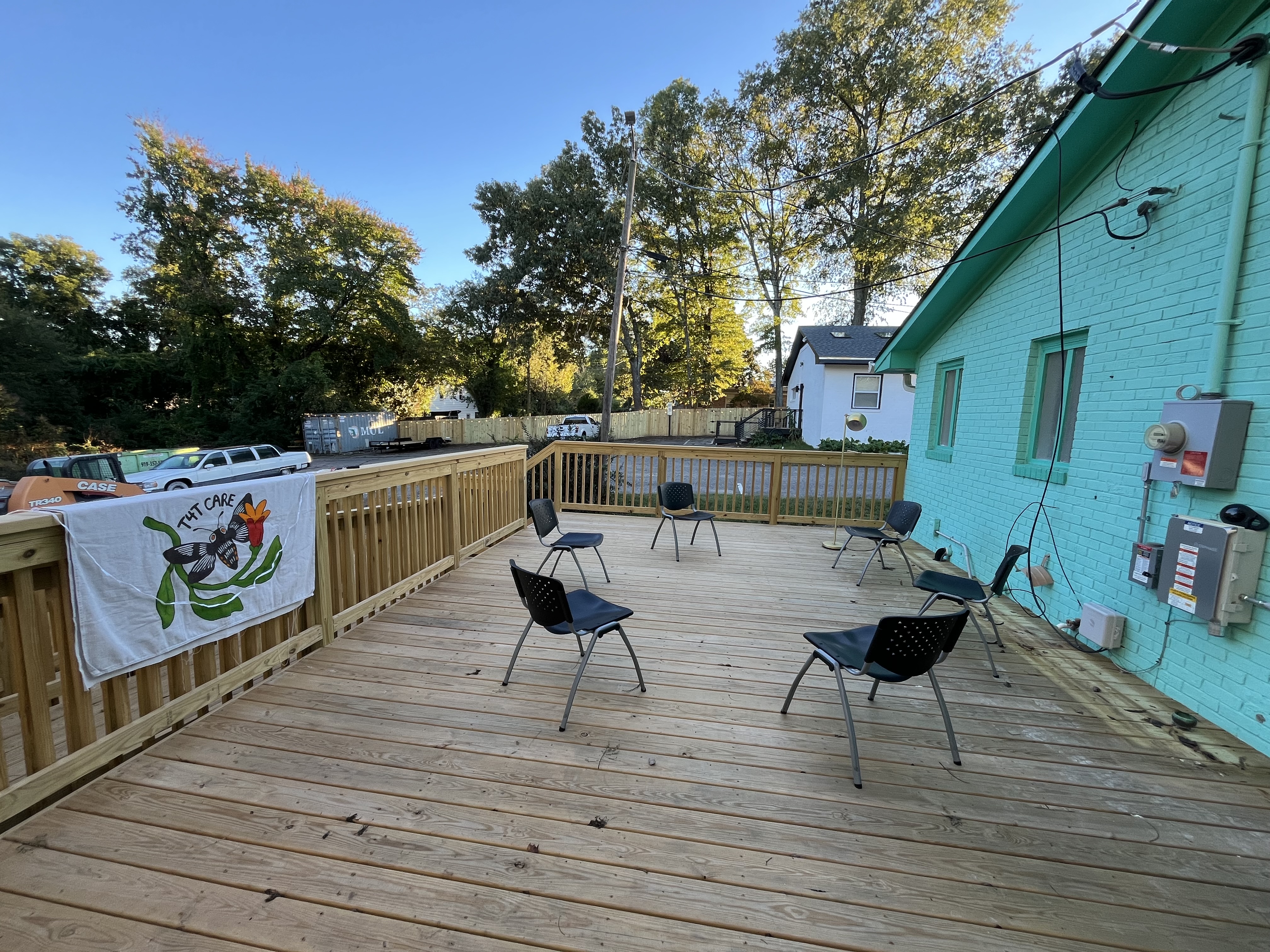 Six chairs gathered in a circle with a T4T Care flag nearby.
